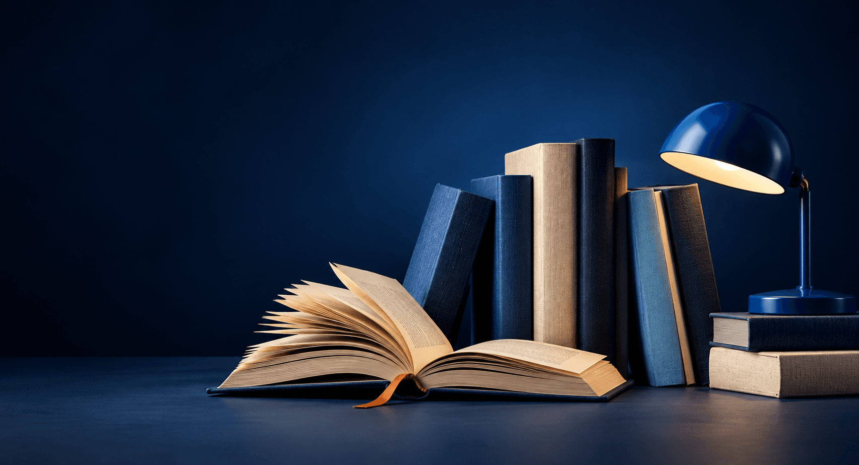 Open book, cloth-bound books and a blue reading lamp